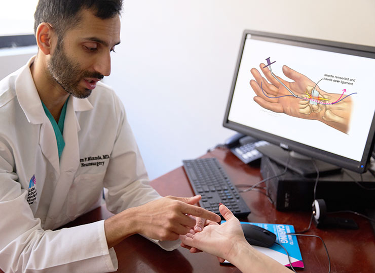 Photo of doctor demonstrating no incision carpal tunnel procedure on patient